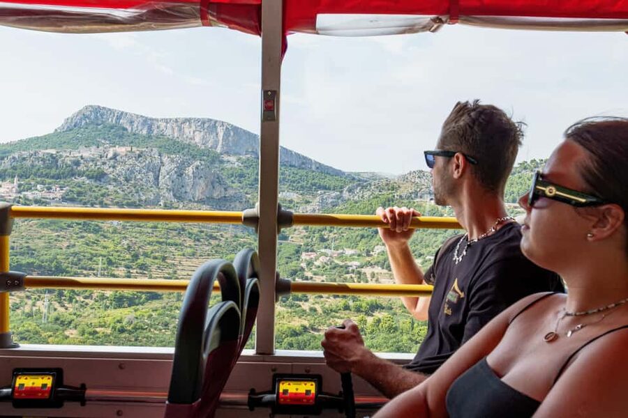 Split: Historical Tour of Salona, Klis Fortress and Trogir - Getting on the open-top red bus near Apodos Travel Agency